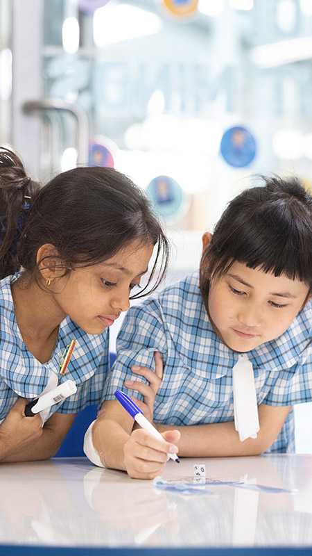 Sacred Heart Primary Mt Druitt students writing on whiteboard in class
